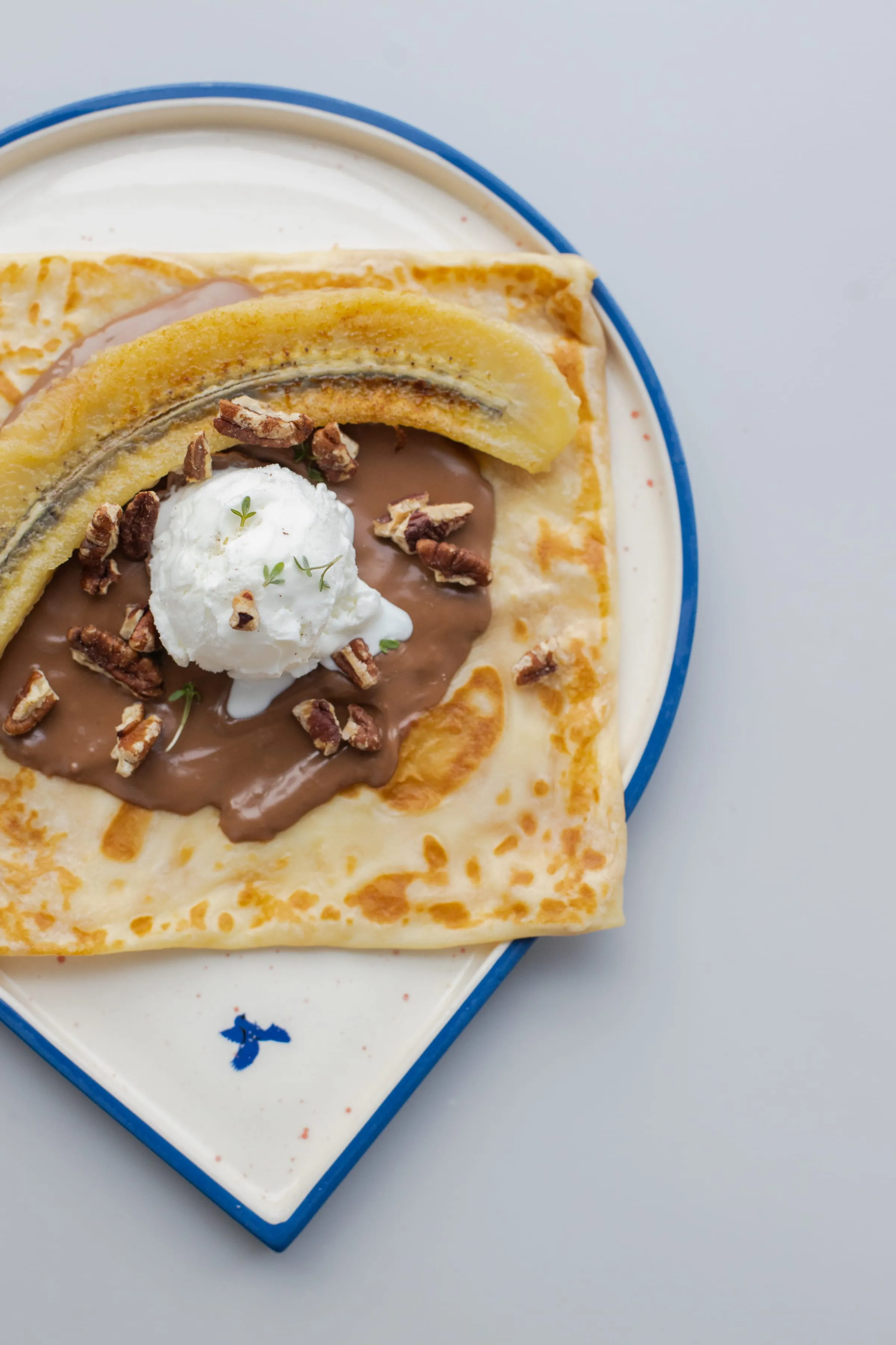 Banana pancake with chocolate, ice cream and pecans
